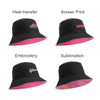 A black bucket hat with a pink underside and various promotional logos in different print styles.