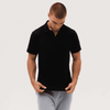 A black polo shirt displayed on a model, featuring a simple design and a logo on the chest.