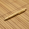 A bamboo pen with a natural finish, featuring a clip and branding. The background is made of bamboo material.