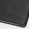 A black diary with a textured cover and embossed branding, featuring white stitching along the edges.