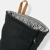 A black oven mitt with a striped interior and a hanging loop, featuring a small logo.