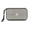 A rectangular grey bass speaker with a mesh front and a black cord attached for easy carrying.