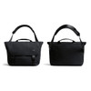A black messenger bag with adjustable strap, featuring a flap closure and carry handles, along with a subtle logo.