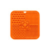 An orange, four-section silicone lick mat with various textures, including paw prints and bone shapes.
