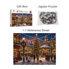 A gift box containing a jigsaw puzzle with a festive Christmas scene, featuring a decorated tree and snow-covered buildings.