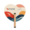 A heart-shaped wooden paper fan featuring orange, blue, and cream colours, with a logo on one side.