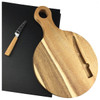 A round wooden cheeseboard with a handle, accompanied by a cheese knife with a wooden handle, on a black backdrop.