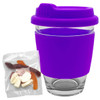 A reusable coffee cup with a purple silicone sleeve and lid, accompanied by a small pack of jelly lollies.