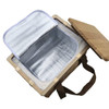 A square wicker picnic cooler basket in natural wood with a beige lid and an insulated silver interior.