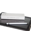 A metal pen in white lies next to a boxed product on a tablet surface. The box features a branding logo.