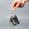 A black tape measure is being held by a hand, showcasing its sleek design and branding.