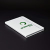 A white A5 notebook with a logo on the cover and an elastic band for closure.