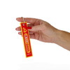 A red and yellow woven keytag featuring a logo, held by a hand with manicured nails.