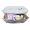 A cream-coloured bag contains various Tilley products, including soap and skincare items in purple and white packaging.