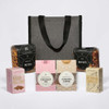 A grey cooler bag with assorted snacks: pretzels, beer nuts, marshmallows, traditional coconut ice, caramel fudge, and drinking chocolate.