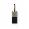 A sleek keytag featuring a black leather base and a silver metallic top, attached to a metal ring.