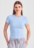 A light blue women's baby tee, featuring short sleeves and a fitted design, worn with grey joggers.
