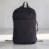 A black backpack with a sleek design and a front pocket, featuring straps and a logo on the side.