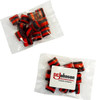 A clear bag containing red and black striped humbugs. The bag has a logo on it.
