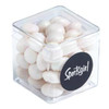 A clear cube container filled with white chewy mints, featuring a circular black logo.