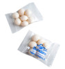 A small clear packet containing eight white mint candies, branded with a logo.