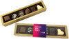 A gold box containing assorted pralines, including dark, milk, and white chocolates, with decorative patterns.