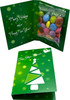 A green card featuring a Christmas tree design, containing a clear bag of colourful Smarties.
