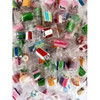 Individually wrapped rock candy in various colours, including pink, green, blue, and red, arranged in a large pile.