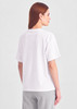 A women's white box tee with short sleeves, featuring a simple design and a visible logo on the back.
