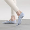 A pair of light blue yoga toe socks with a textured grip sole, worn by a person in fitted pants.