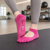 Open top yoga toe socks in vibrant pink, featuring grip dots on the sole and a logo on the upper side.
