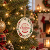 A ceramic ornament featuring festive colours and designs, hanging on a decorated Christmas tree.