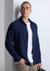A navy long sleeve shirt with a button-up front, worn over a white t-shirt, paired with beige trousers.