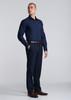 A navy long sleeve shirt is worn by a model, paired with dark trousers and brown shoes. The shirt features a logo.