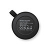 A round black wireless speaker with a textured surface and a hanging loop, featuring technical specifications on the back.