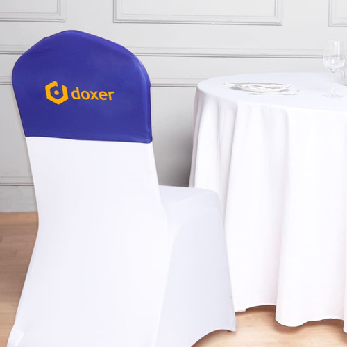 A half chair cover in blue and white featuring a logo, placed on a chair next to a table with a white tablecloth.