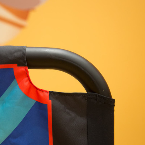 A black sidewalk café barrier with a colourful design attached to a curved metal frame.