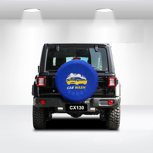 A blue spare tyre cover with a design featuring a car and the text "CAR WASH," placed on a black vehicle.