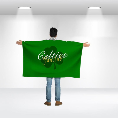 A person wearing a large green flag with a logo and text on the back, standing in a well-lit space.