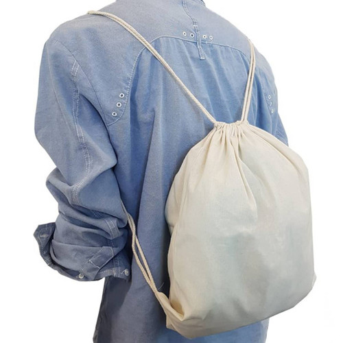 A cream drawstring bag is worn on the back, secured by matching drawstrings, against a light blue shirt.