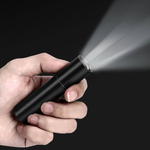 A black torch held in a hand, emitting a beam of light against a dark background.