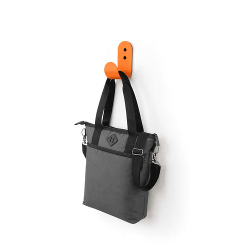 A grey laptop tote bag with black straps hanging on an orange wall hook. It features a logo.