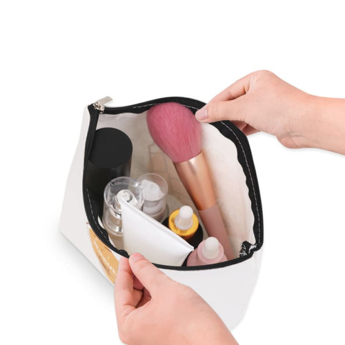 A canvas cosmetic bag in white, filled with various beauty products, including bottles and a makeup brush.