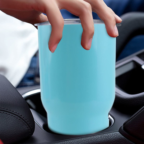 A turquoise 30oz double wall stainless steel tumbler with a lid, placed in a car’s cup holder.