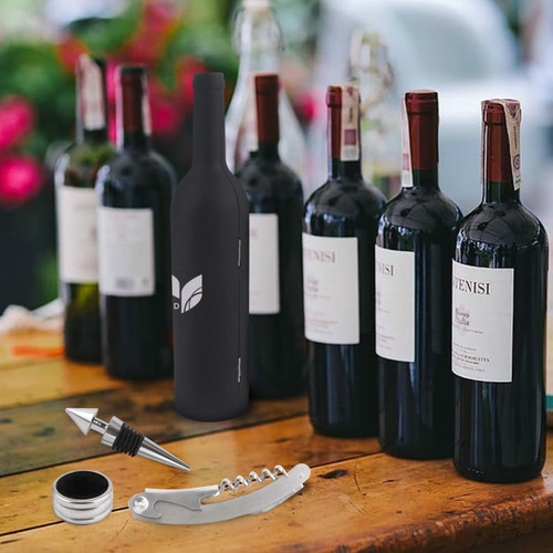A drink bottle shaped wine tools set in black, including a corkscrew, wine pourer, and bottle stopper, against red wine bottles.