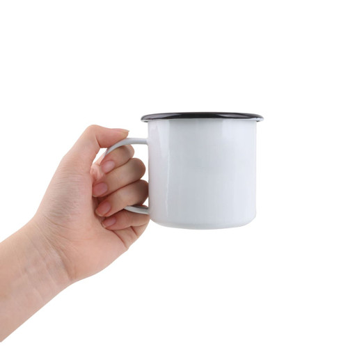 A 350ml enamel camping mug in white with a black rim, held in a hand. The mug has a simple design and a handle.