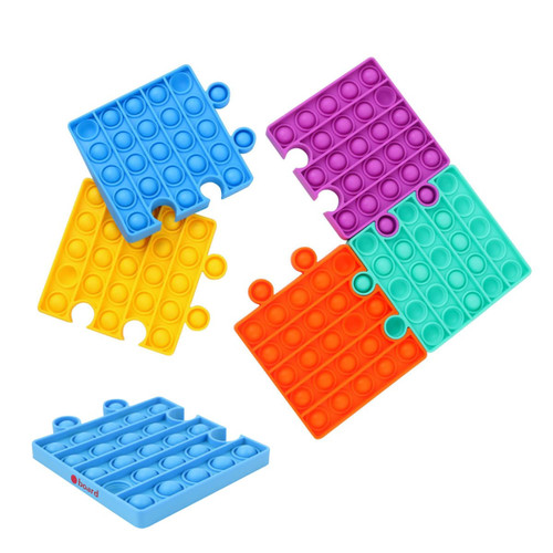 A set of puzzle-shaped Pop It fidget toys in blue, purple, green, orange, and yellow. Each piece features raised bubbles.