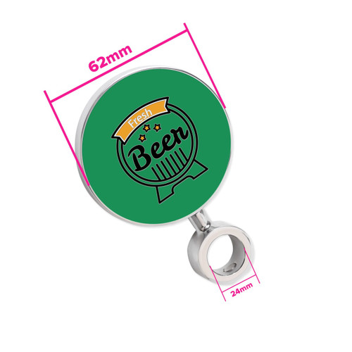 A circular green beer tap badge with a silver attachment, featuring a decorative design. Measures 62mm in diameter.