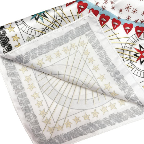 A silk satin scarf featuring a vibrant design with red hearts and star patterns on a white background.