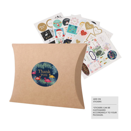 A large brown kraft pillow box with a circular logo and various decorative stickers in the background.